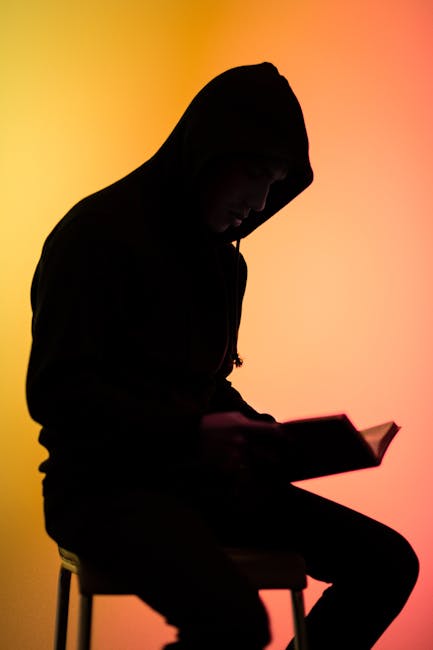 Silhouette of a person in a serene yoga pose against a ruby-red background